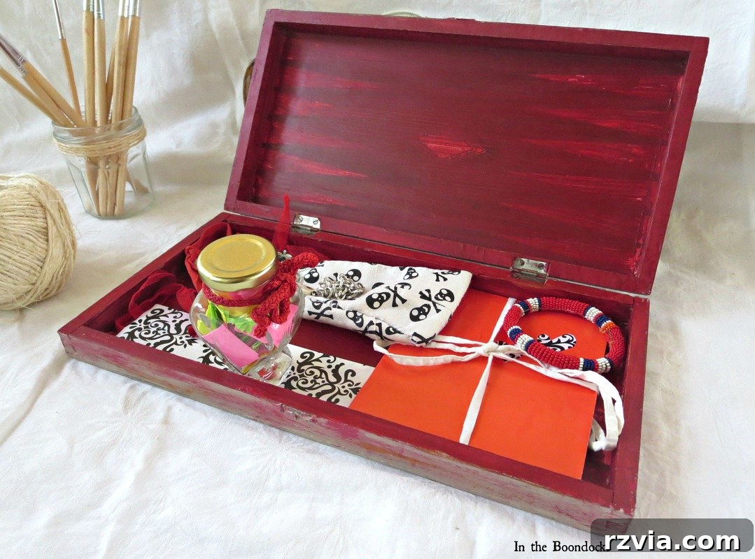 The open, finished box, filled with various small homemade gifts and treats. The red interior is visible, contrasting with the rustic exterior, and the contents demonstrate the thoughtfulness of a handmade gift set.