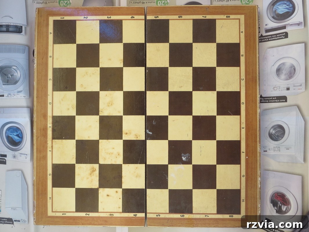 An old, worn laminate box, featuring a chess board pattern on its exterior. This is the 'before' image of the box, showing its original state with visible signs of use and age, making it a perfect candidate for a creative DIY transformation. The box clearly needs a makeover.