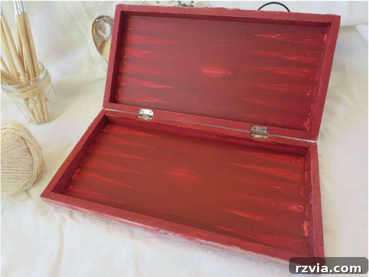 The inside of the refurbished box, painted with a vibrant red acrylic paint. The smooth, clean application of red on the interior contrasts beautifully with the textured exterior, creating a delightful surprise when the box is opened.