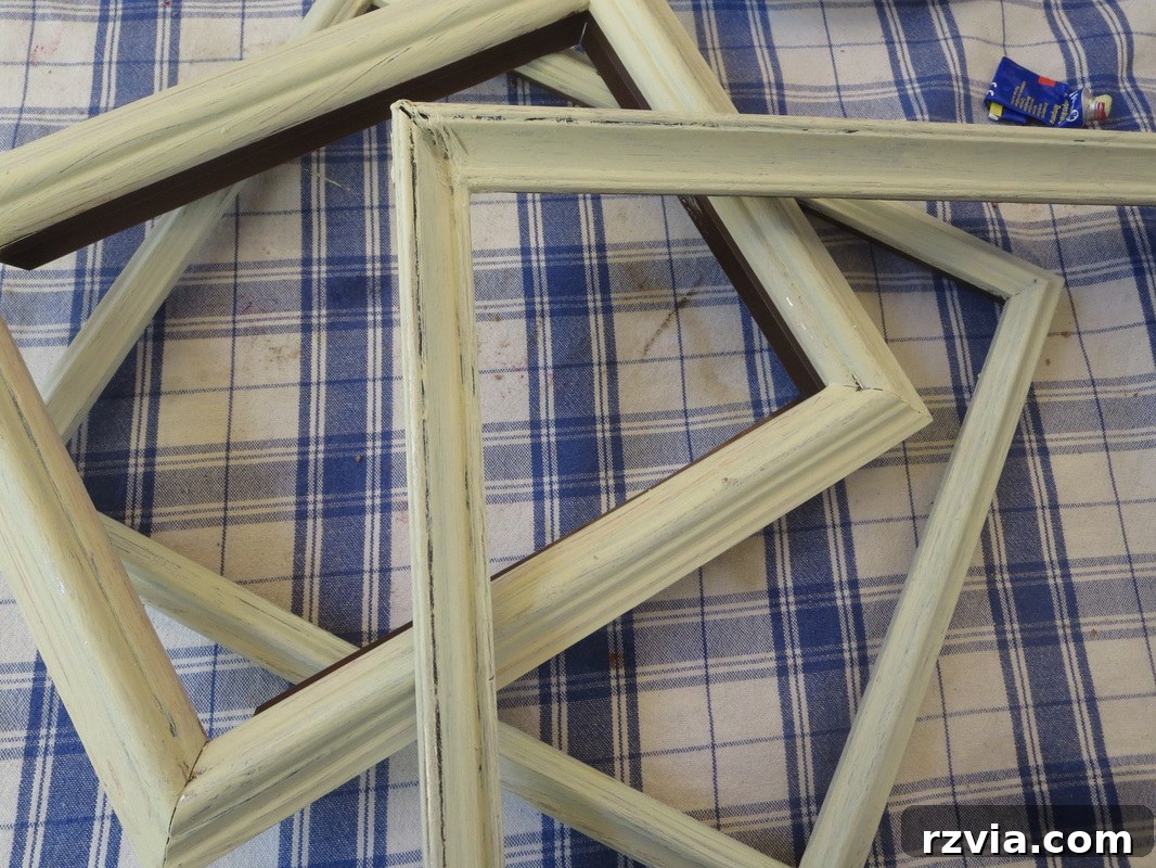 Picture frames after the first coat of custom-mixed white and silver paint, a crucial step in 'Banishing the Shine' for a distressed shabby chic look.