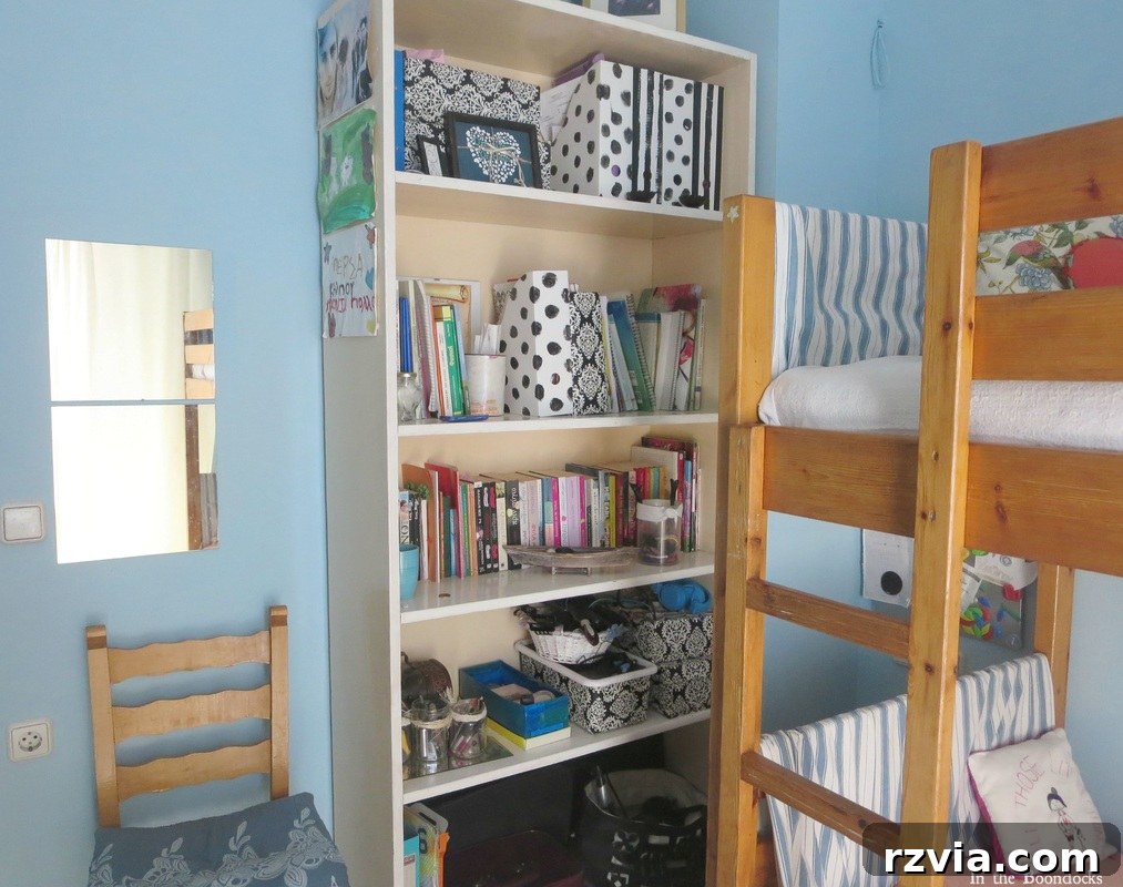 Repurposed Chic: A Teen Girl's Unique Bedroom Makeover 11 Bookcase strategically placed in the corner of the blue teen room, offering both storage and style.