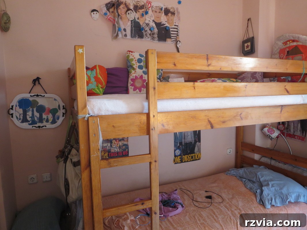 Repurposed Chic: A Teen Girl's Unique Bedroom Makeover 3 Before: Cluttered bunk bed area with peach walls, showcasing the need for a teen bedroom makeover.
