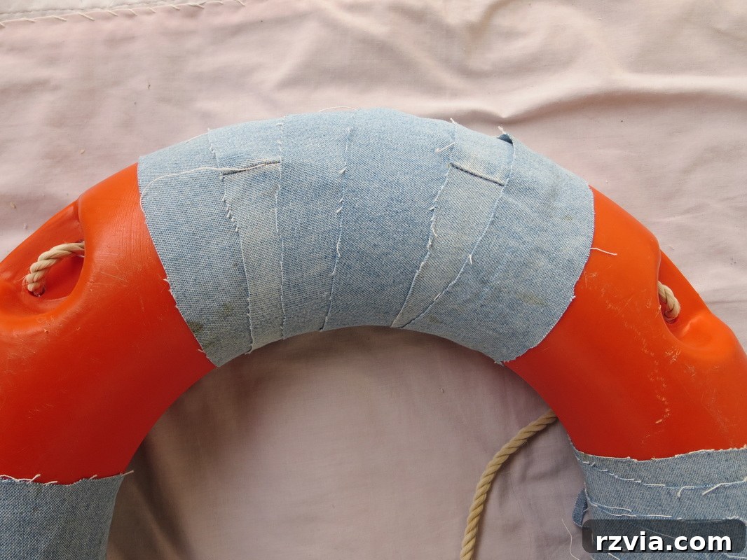 Adding strips of denim, twine, and ribbon to the lifesaver for a rustic, coastal look.