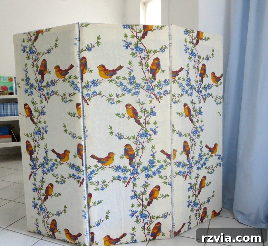 Folding panel partition made with laminate boards, batting, and fabric, shown in a multi-functional room