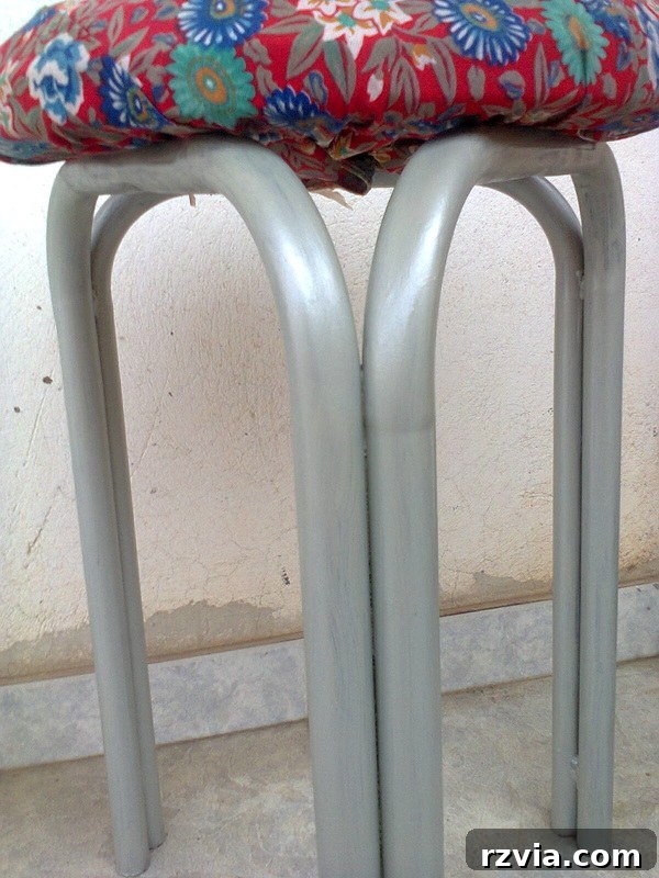 Closeup of the stool's legs, highlighting the pearly finish and metallic sheen.