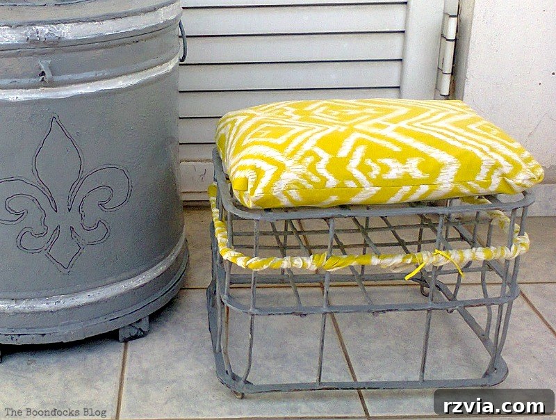 Detailed shot of the custom-made cushion on the repurposed milk crate stool, showcasing the texture and vibrant color. DIY upcycled furniture close-up.
