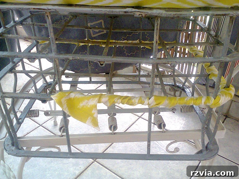 Decoratively wrapping colorful fabric scraps around the metal bars of the grey-painted milk crate to add visual interest. Creative upcycling ideas for home decor.
