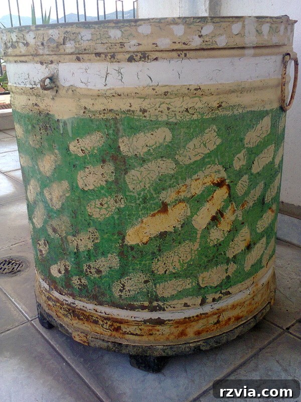 Side view of a very rusty barrel, previously painted by kids