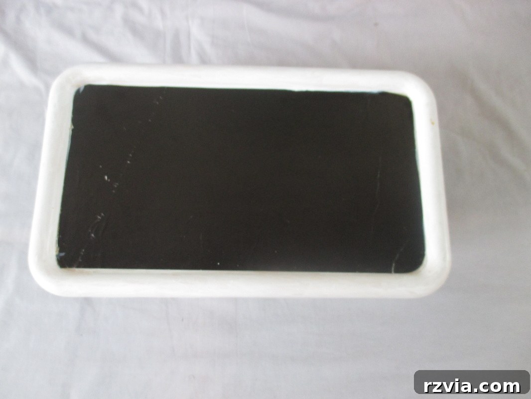 Decoupaging paper onto the top of the box, illustrating the process of transforming color to black and white