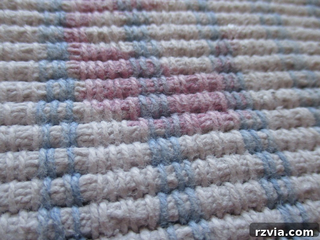 Close-up of a blue and white rug with a visible pink nail polish stain.