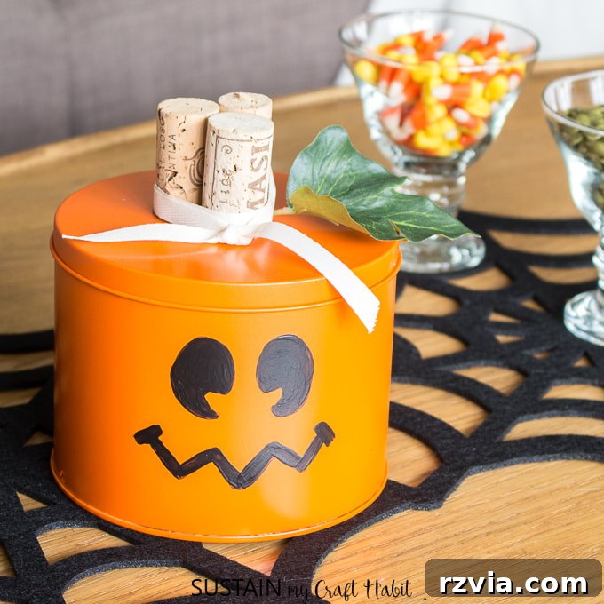 Upcycled tin can transformed into a Jack O' Lantern for Halloween decor by Sustain My Craft.