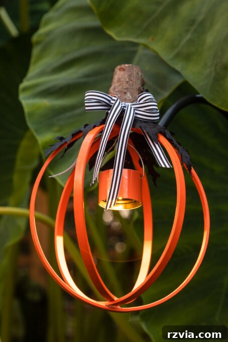 Upcycled embroidery hoop transformed into a charming pumpkin lantern, glowing warmly for Halloween decor.