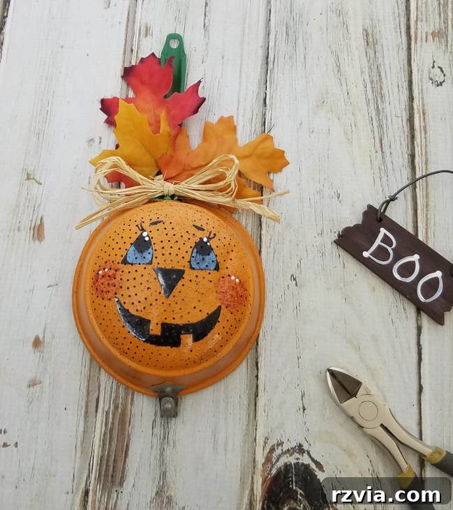 Vintage metal strainer upcycled into a unique Jack O' Lantern for Halloween decor by Mixed Kreations.