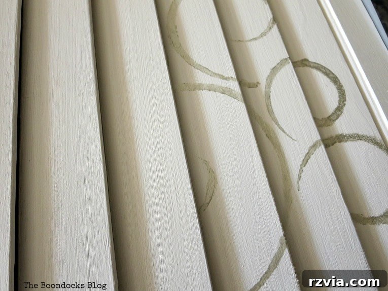 Unconventional Shutter Stenciling Secrets 13 The improved results of stenciling by inserting the stencil between the slats, showcasing clear and defined metallic silver swirl patterns. This technique overcomes the challenges of uneven surfaces.