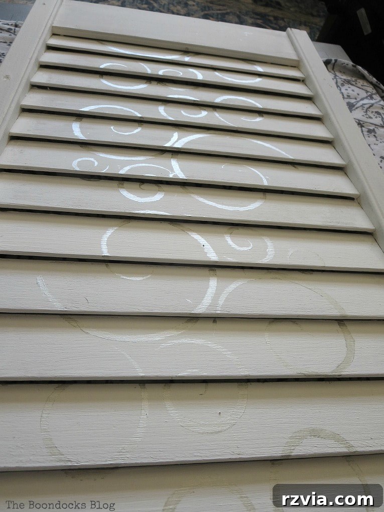Unconventional Shutter Stenciling Secrets 15 The central section of the shutter stenciled with subtle metallic silver swirls, demonstrating the delicate effect achieved. Discover how to assess your DIY project for balance and completeness.
