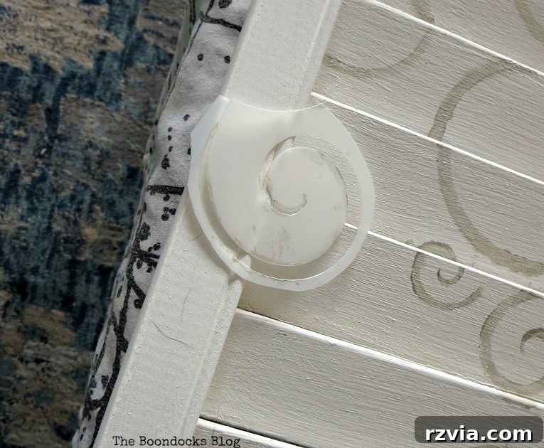Unconventional Shutter Stenciling Secrets 16 Enhancing the shutter art by adding smaller swirl patterns to the sides of the central design, cutting pieces from the original stencil for balance and visual richness. A creative solution for refining DIY projects.