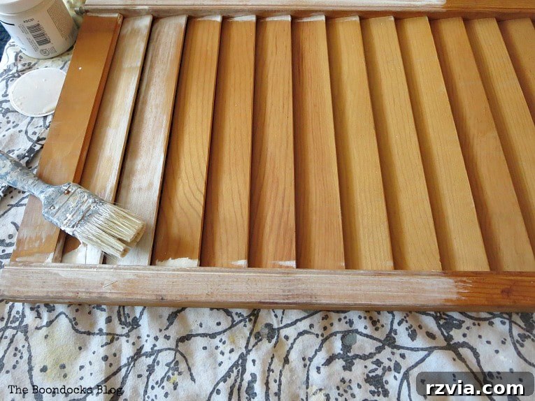 Unconventional Shutter Stenciling Secrets 3 Applying the first coat of DecoArt Americana Chalky Finish Paint in Everlasting to the rescued shutter. Learn how this base coat sets the stage for stunning DIY stenciled shutter art!