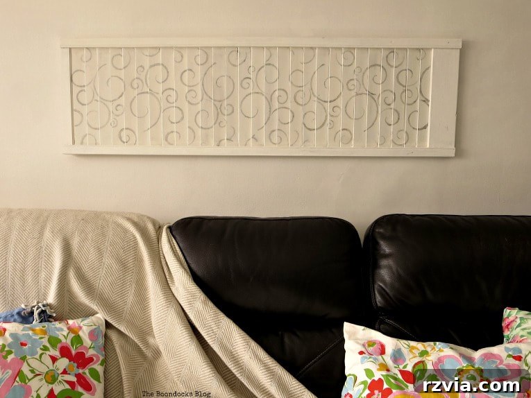 Unconventional Shutter Stenciling Secrets 18 The newly stenciled shutter art proudly displayed above the sofa, perfectly filling the horizontal space. This unique DIY piece brings a touch of farmhouse charm and personalized style to the living room. #shutterart #stenciledshutter #chalkyfinishpaint #DecoArtMedia #DIYArt #Stenciledswirls