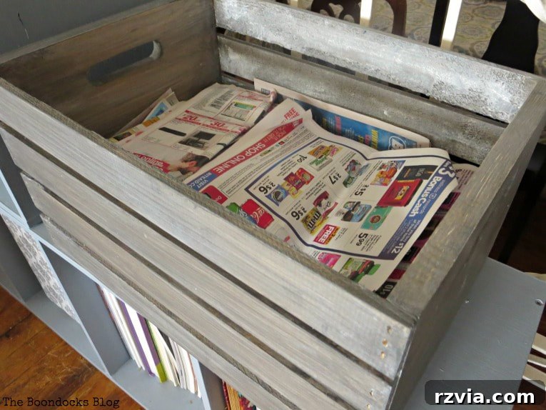 The newly stained wooden crate, now serving as stylish and practical storage for newspapers.