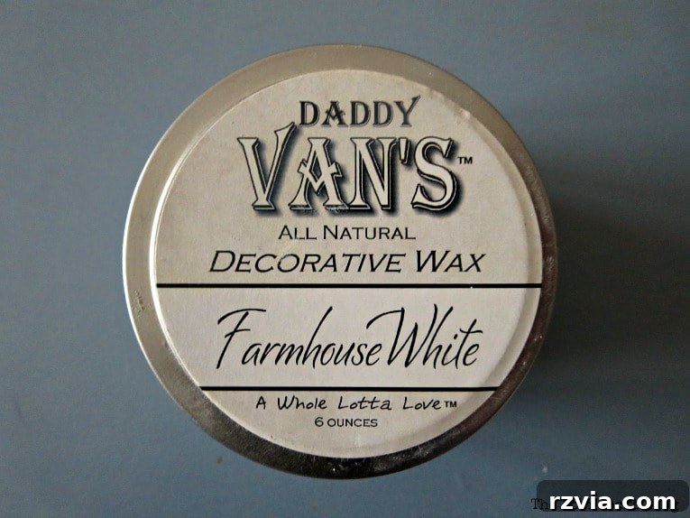 Applying Daddy Van’s All Decorative Wax in Farmhouse White to the stained wooden crate to seal and enhance its rustic finish.
