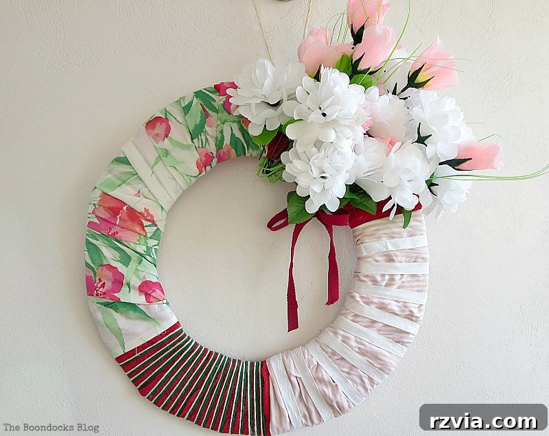 From Discarded to Desired: Upcycling Your Clothes with Style 11 A colorful, lopsided summer wreath artfully created from repurposed fabric scraps, including pieces of a skirt, a shirt, and gauze material.