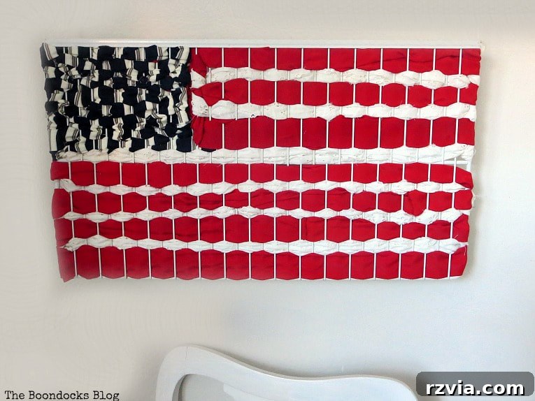 From Discarded to Desired: Upcycling Your Clothes with Style 3 A patriotic American flag wall art piece crafted entirely from repurposed fabric scraps.