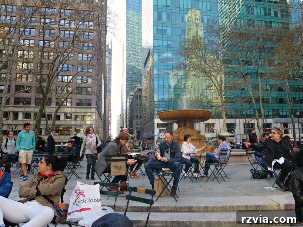 The elegant Josephine Shaw Lowell Memorial Fountain, surrounded by people and movable chairs, gracing the west side of Bryant Park, New York.