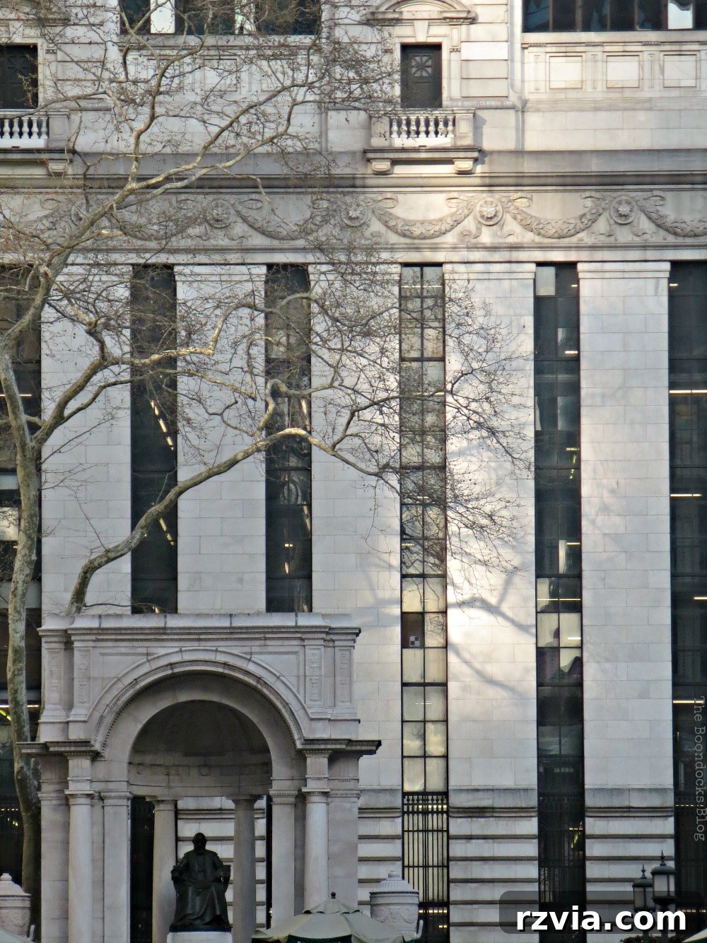 Close-up view of the New York Public Library building with patches of sunlight, illustrating the beauty and historical significance of Bryant Park.