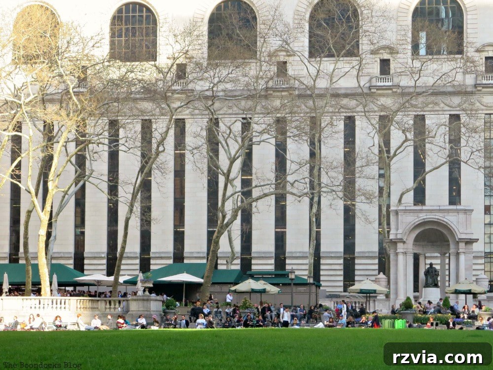 Tall narrow windows of the New York Public Library, indicating the library stacks, with the welcoming Bryant Park Cafe visible in the foreground.