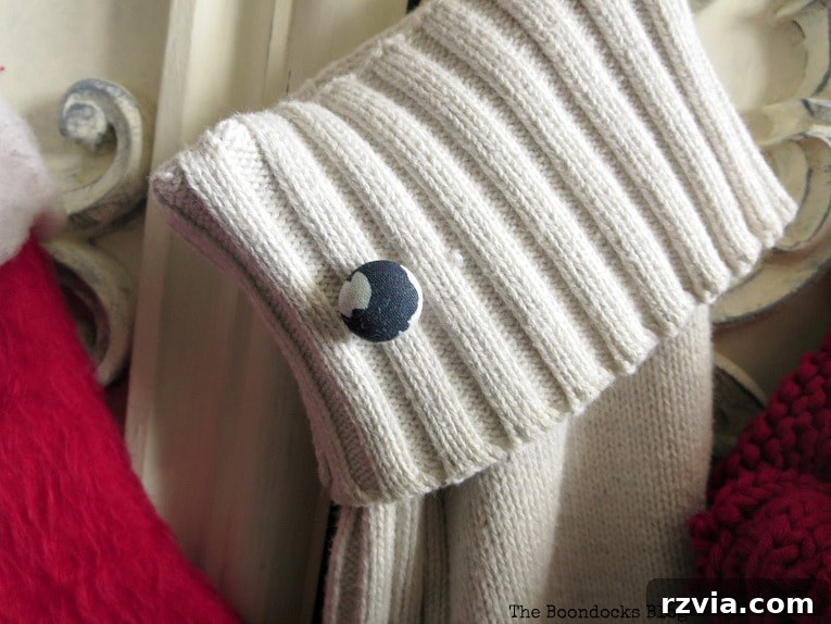 Repurpose Old Sweaters into Christmas Stockings 10 A white sweater stocking with a black and white button, made from a repurposed sweater sleeve, for our dog.