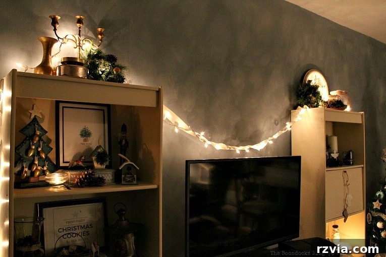 Repurpose Old Decor for Stunning Christmas Vignettes 2 Beautifully lit bookcases in a living room, showcasing creative Christmas vignettes made from reused decor, a perfect example of how to make old items shine for the holidays.