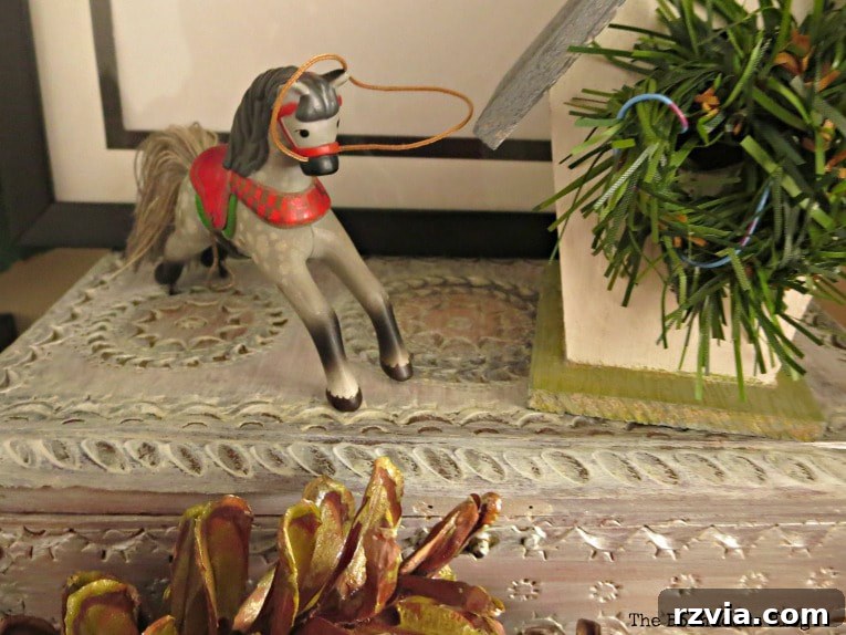 Repurpose Old Decor for Stunning Christmas Vignettes 14 A horse ornament gracefully placed on a vintage, repainted jewelry box, illustrating the combination of cherished items and DIY makeovers in holiday decor.