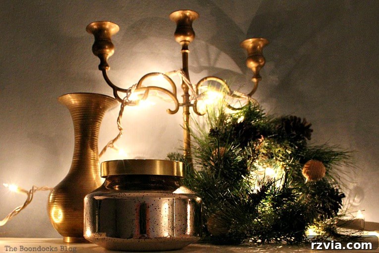 Repurpose Old Decor for Stunning Christmas Vignettes 20 The top of a bookcase elegantly decorated with a candelabra, wreath, jar, and vase, creating a grand and illuminated Christmas vignette.
