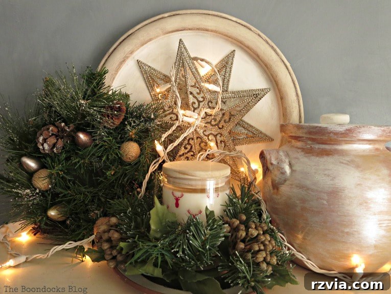 Repurpose Old Decor for Stunning Christmas Vignettes 21 Another view of the top of the bookcase, adorned with a star ornament, candle, ceramic pot, and a beautifully enhanced wreath, contributing to the festive decor.