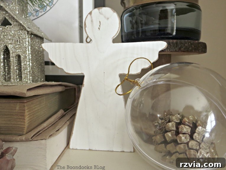 Repurpose Old Decor for Stunning Christmas Vignettes 4 A close-up of a wooden angel ornament, part of a blue and white Christmas vignette, highlighting the charm of repurposing holiday decorations.