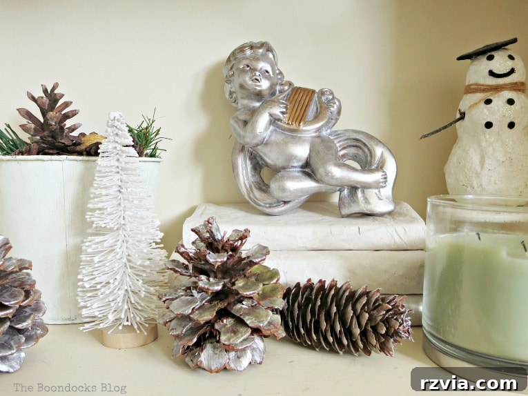 Repurpose Old Decor for Stunning Christmas Vignettes 7 A harmonious silver and white Christmas composition featuring a cherub and snowman, illustrating an elegant and coordinated holiday display.