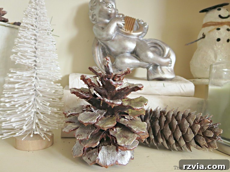 Repurpose Old Decor for Stunning Christmas Vignettes 8 A close-up of silver-painted pine cones paired with a white bottle brush tree, showcasing a clean and elegant silver and white Christmas theme.
