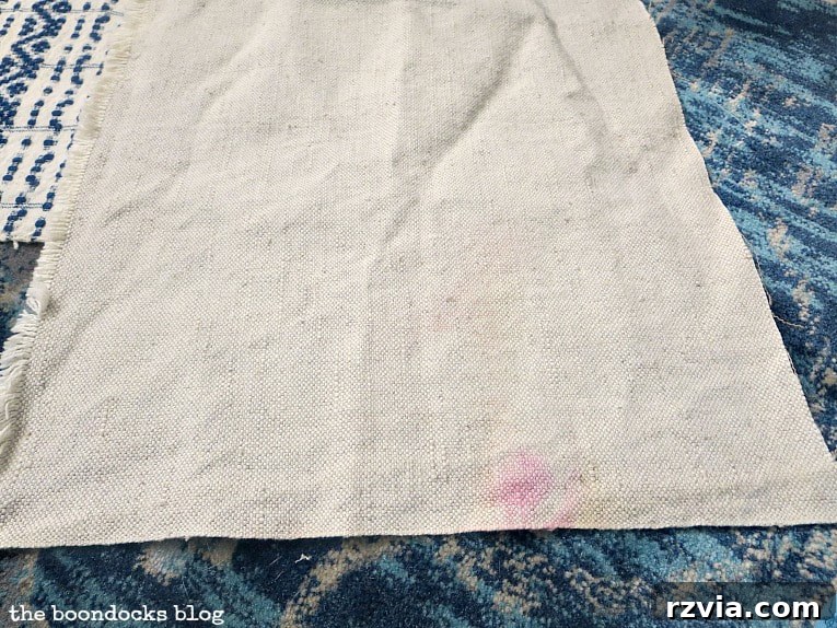 Upcycle Your Fabric Scraps: 5 Easy Pillow Projects 15 Piece of natural linen fabric, showing a slight red stain from a laundry mishap, destined for upcycling.