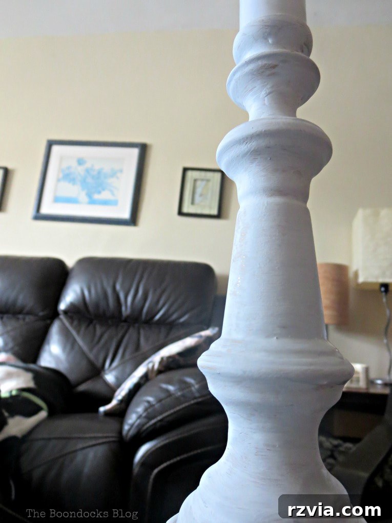 Give Your Lamp Base a High-End Stone Look 4 Applying the first coat of white chalk-style paint to the lamp base. The brush strokes are visible, indicating the initial layering process. The base is fully covered in white, preparing it for subsequent layers.