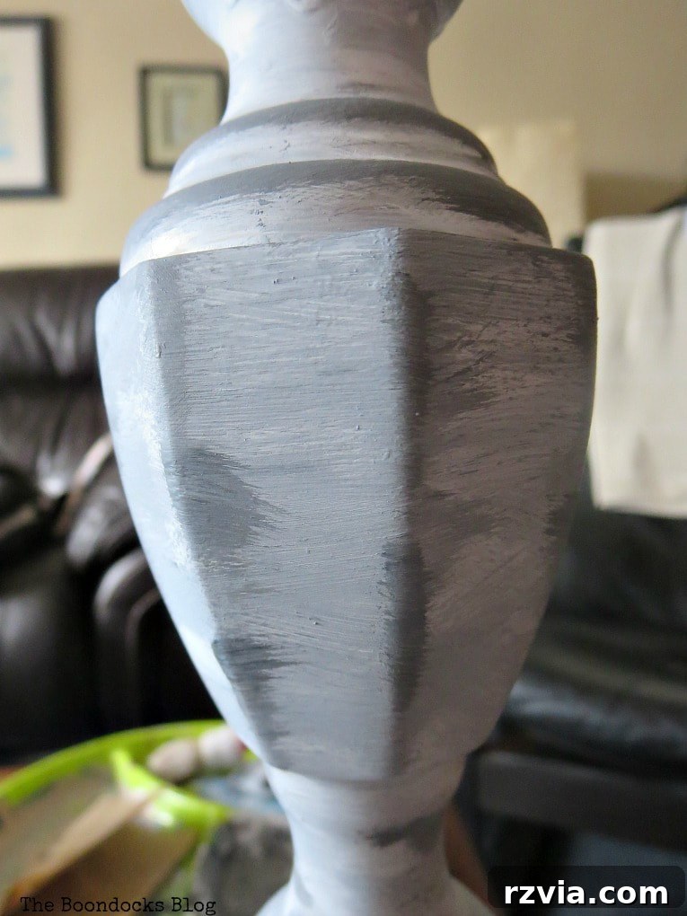 Give Your Lamp Base a High-End Stone Look 6 Close-up detail of the lamp base with layered light grey paint applied over the darker grey and white. The texture is beginning to form, showing a blend of colors and uneven application that mimics natural rock surfaces.
