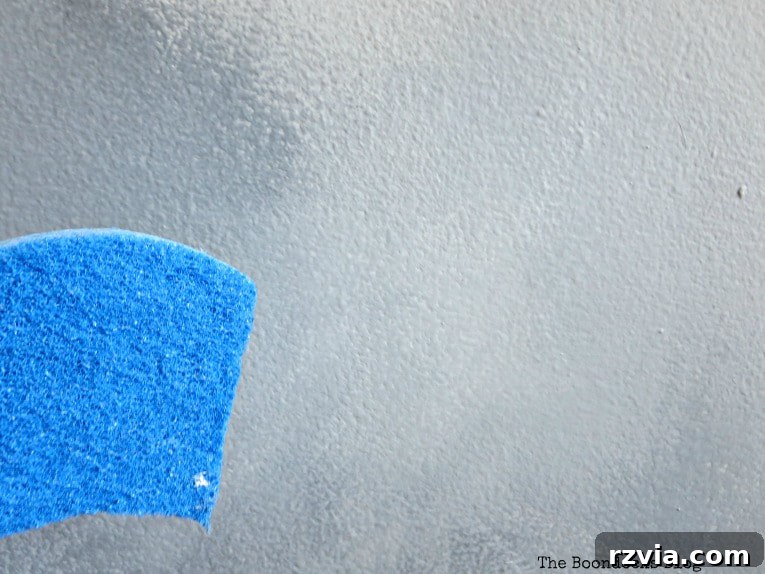 Create Your Own Dreamy Cloud Accent Wall 11 Blending dried paint colors with a slightly wet sponge to achieve a seamless, cloudy effect on the wall.