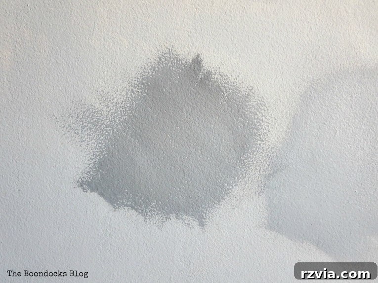 Create Your Own Dreamy Cloud Accent Wall 8 Applying a swatch of the dark blue shade of milk paint to the wall, forming the initial cloud shape.