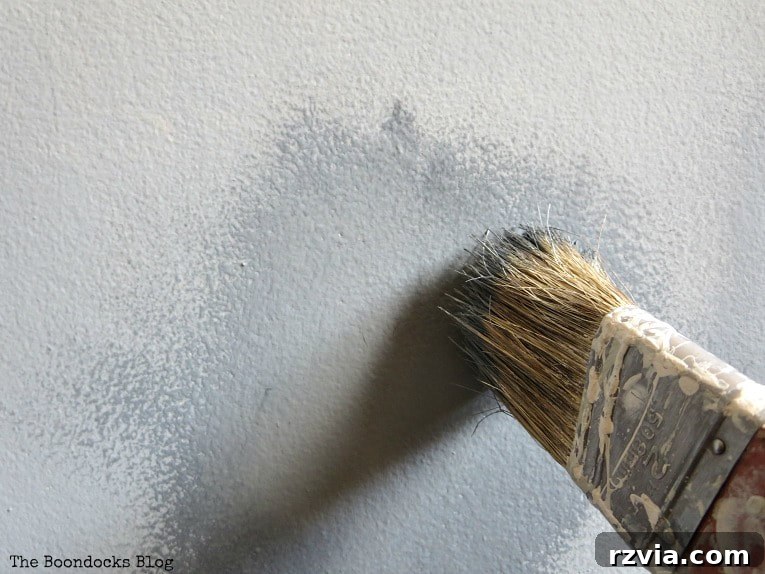 Create Your Own Dreamy Cloud Accent Wall 10 Using a dry brush to blend the dark and light paint swatches, creating a soft, cloud-like transition.