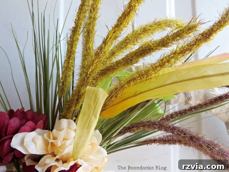 Close-up of colorful wheat grass stems integrated into the DIY fall wreath, adding an earthy, harvest-inspired element.