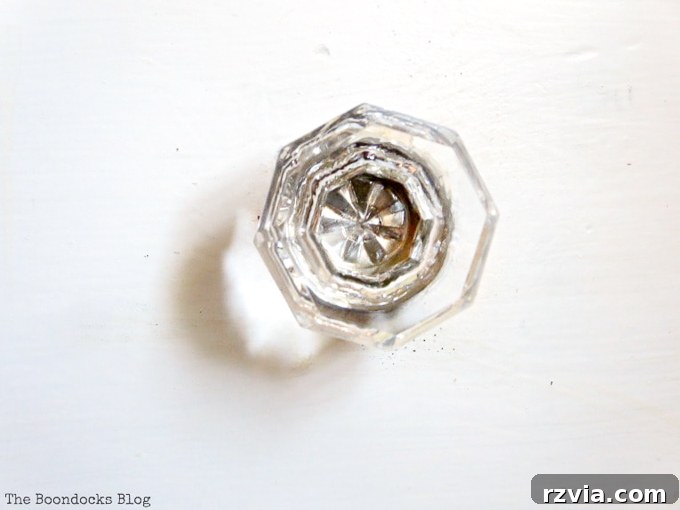 Jewel Your Furniture: Crystal Knobs for an Instant Upgrade 6 Detailed close-up of a sparkling crystal glass knob with a nickel base, enhancing vintage dresser charm.