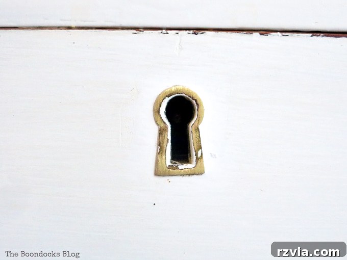Jewel Your Furniture: Crystal Knobs for an Instant Upgrade 8 Rediscovered and cleaned keyhole on a distressed vintage dresser, adding historical charm.
