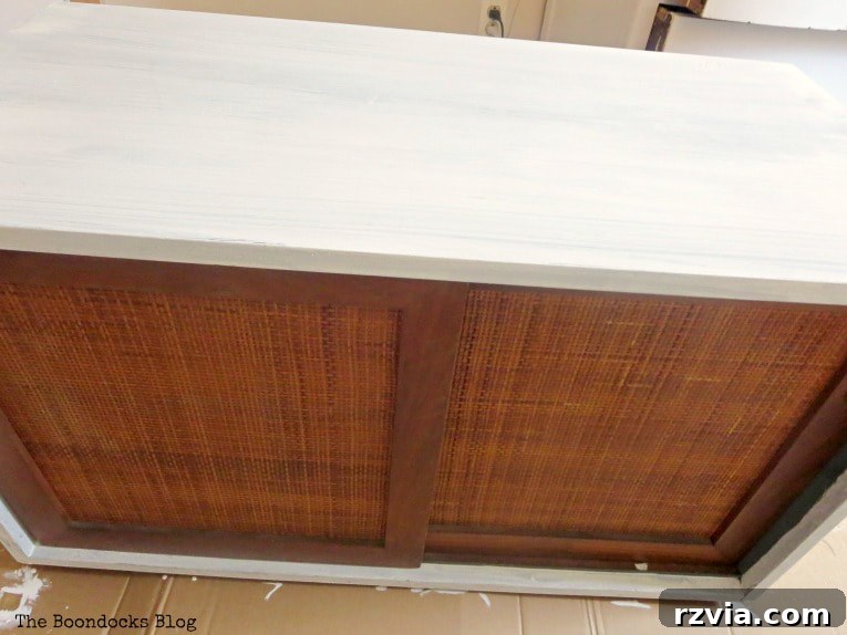 Mid Century Modern sideboard freshly painted with the initial coat of Snow White milk paint, preparing it for the next layer.