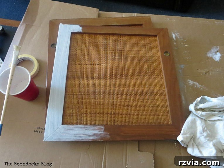 Sideboard doors being carefully painted with Snow White milk paint, highlighting the detailed work on the frames.