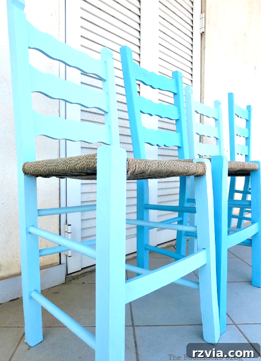 Revamp Your Wooden Chairs: Painting Made Easy 2 Four beautifully painted wooden dining chairs in varying shades of blue, creating an ombre effect, lined up against a white wall. This DIY chair makeover uses chalk paint for an easy transformation.