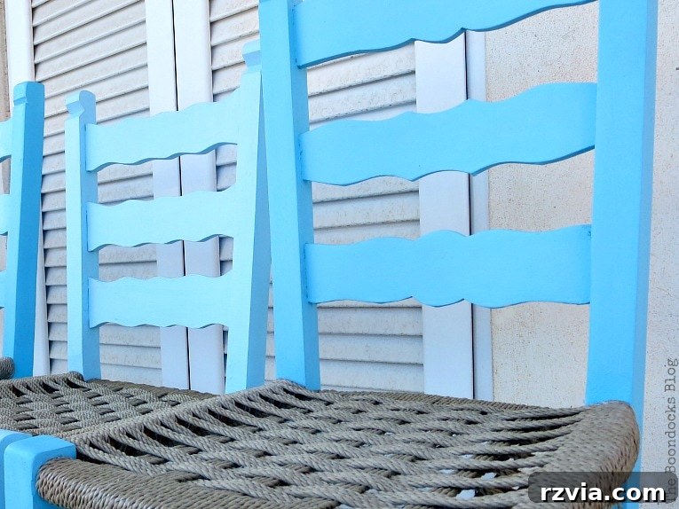 Revamp Your Wooden Chairs: Painting Made Easy 8 Detail shot of a hand applying clear cream wax to a blue painted wooden chair, sealing the chalk paint finish for protection and durability.